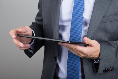 Close up of business man hands reading something on his tablet pcの写真素材