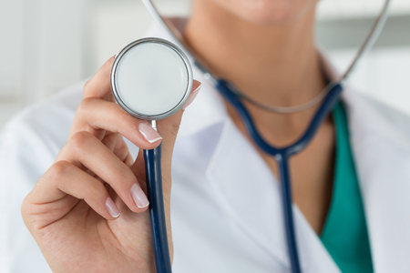 Close-up of female doctor hand stethoscope head ready to examin patient. Healthcare and medical conceptの写真素材