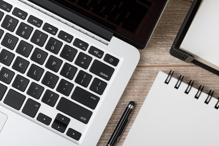 Close-up top view of business man or designer working place. Laptop, notebook and pen