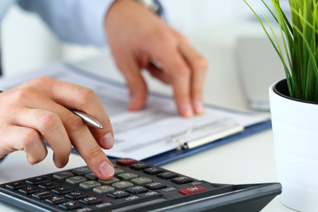 Close up view of bookkeeper or financial inspector hands  making report, calculating or checking balance. Home finances, investment, economy or insurance conceptの写真素材