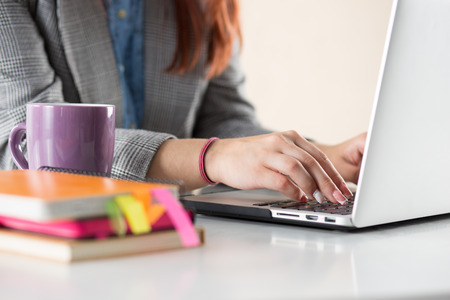 Close up view of businesswoman, designer or student hands working on laptop. Online distant education, writing blog, freelance, mobile payments, working at office or at home concept.の写真素材