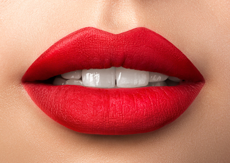 Close up view of beautiful woman lips with purple matt lipstick. Open mouth with white teeth. Cosmetology, drugstore or fashion makeup concept. Beauty studio shot. Passionate kissの写真素材