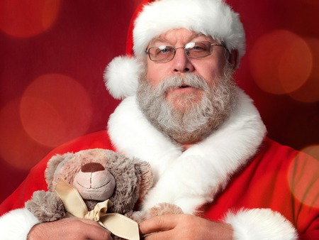 Portrait of Santa Claus holding teddy bear. Christmas celebration, gift to good and nice children concept.の写真素材