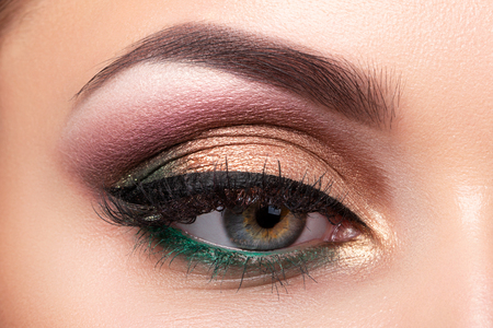 Close up of beautiful woman eye with multicolored smokey eyes makeup. Modern fashion make up. Studio shotの写真素材