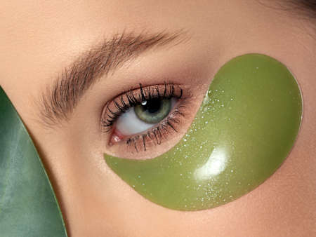 Closeup of woman eye with green patch under itの写真素材