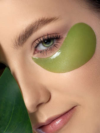 Woman with green eye patches under her eyesの写真素材