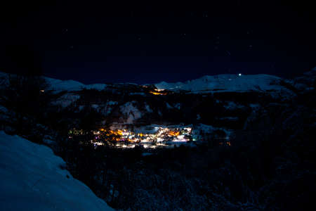 Lighting village in mountains at night, snow, New Yearの写真素材