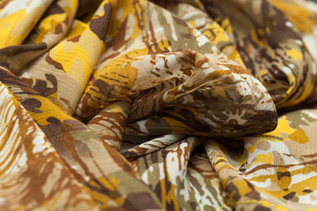 Yellow brown light cloth, fabric, textile with a lot of folds, plaits, creasesの写真素材