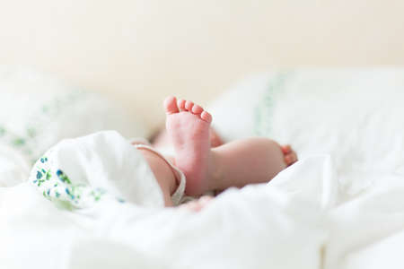 Baby feets in white bedの写真素材