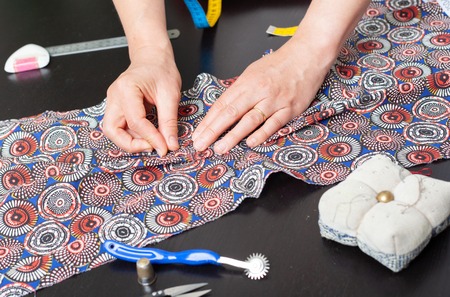 Dressmaker at work, building patterns, hands, modeling, measuring, fashion sewing machine material...
