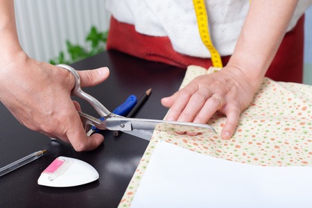 Dressmaker at work, building patterns, hands, modeling, measuring, fashion sewing machine material clothing textileの写真素材