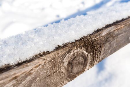 Frost snowflakes on wood, bridge with sun and snow at winterの写真素材