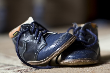 old blue worn children's boots on a carpetの写真素材