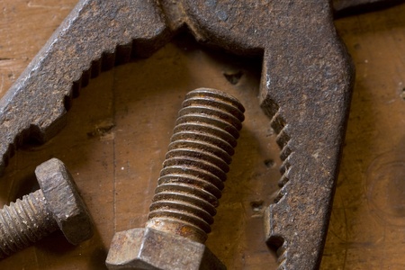 old rusted pliers and screwbolts on workbenchの写真素材