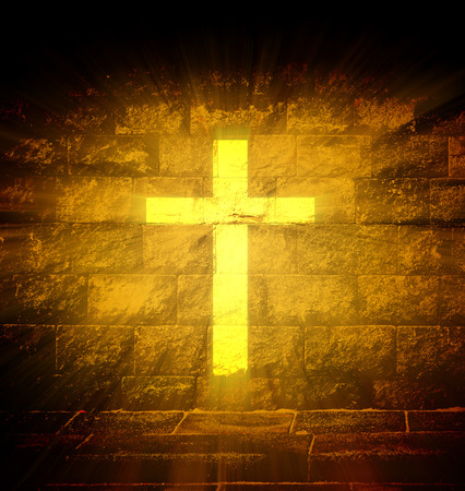 Christian religious cross with gold light ray on the brick wallの写真素材