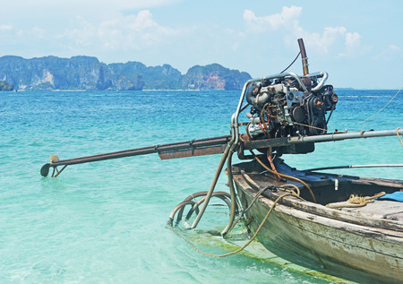Tail boat with motor on a beach