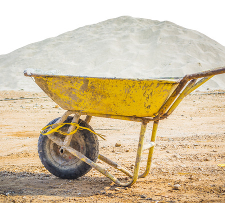 wheelbarrow for construction parked with sand backgroundの写真素材