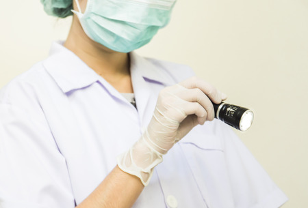 Women doctor using a flashlight, picture for about medical