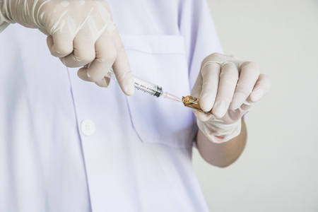 Doctor drawing a solution from bottle for injection, photo about medicalの写真素材