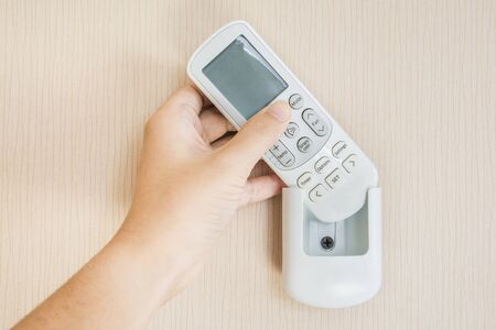 Air condetioner remote control hanging on the wallの写真素材