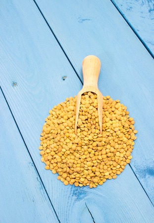 the seeds of green lentils on a blue board closeupの写真素材