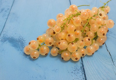 fresh red and white currants on a blue board closeupの写真素材
