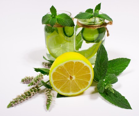 Water with fresh lemon, green leaves mint and cucumber