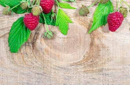 Wooden background with fresh raspberries. Space for text.
