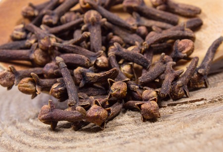 Closeup of dried cloves on a wood board.の写真素材