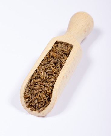 Ground cumin in a spoon, isolated on white background.の写真素材