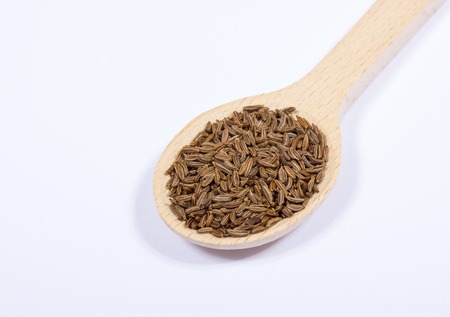 Ground cumin in a spoon, isolated on white background.の写真素材
