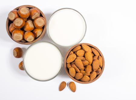 Close up of a glass of hazelnut milk and almonds on a white background.の写真素材