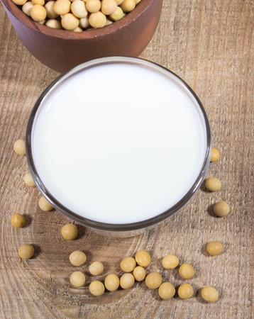 Close up of a glass of soy milk on a wooden background.の写真素材