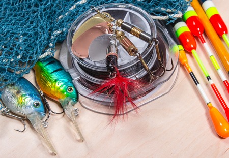 bait, wobbler and fishing accessories on wooden backgroundの写真素材