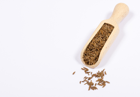 Ground cumin in a spoon, isolated on white background.の写真素材