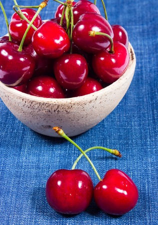 Raw cherries on the jeans background. CloseUp.の写真素材