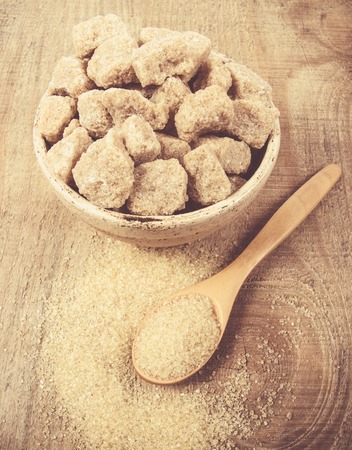 Cubes of sugar - brown sugar cane on the wooden background.の写真素材