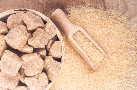 Cubes of sugar - brown sugar cane on the wooden background.の写真素材