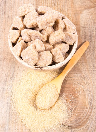 Cubes of sugar - brown sugar cane on the wooden background.の写真素材