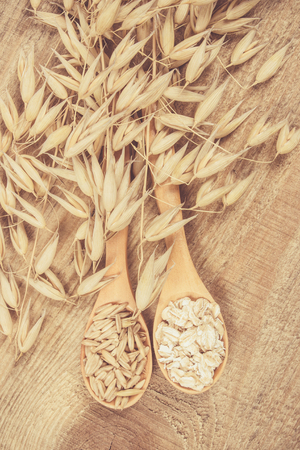 Oatmeal and oatmeal on the wooden background. Healthy eating concept.の写真素材