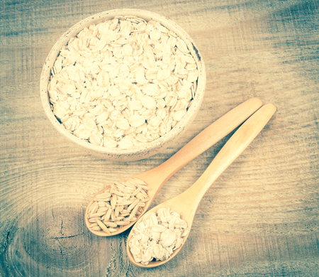 Oatmeal and oatmeal on the wooden background. Healthy eating concept.の写真素材