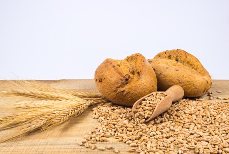 Freshly baked bread rolls on wooden table.