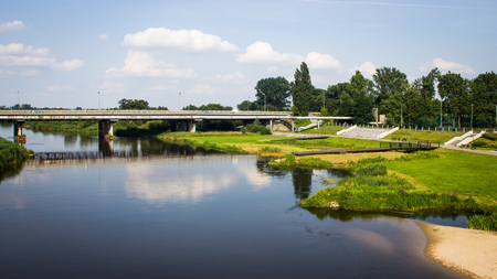 Konin, Poland - July 22, 2017: View on bridge and embankment of Warta river in polish town Konin, Greater Poland provinceのeditorial素材