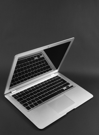 Modern laptop computer on dark background. The concept of work in the office.