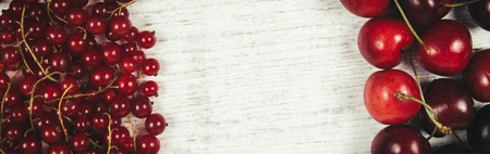 Fresh ripe red currants and cherries on rustic wood background. Place for any inscription.の写真素材