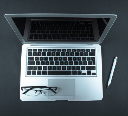 Modern laptop computer on dark background. The concept of work in the office.の写真素材