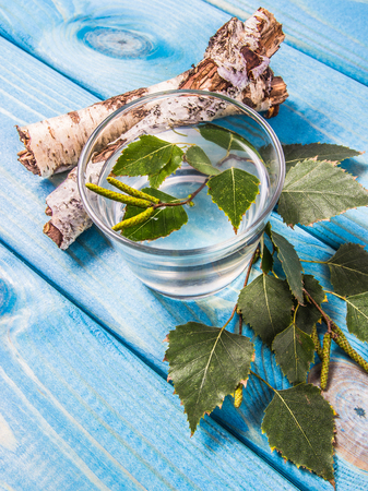 A glass of birch juice on blue wooden background. Close Up.の写真素材