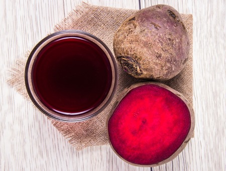 Homemade organic healthy beetroot juice and fresh vegetables on rustic wooden background.