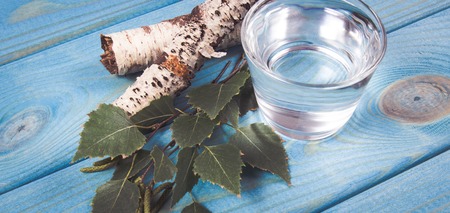 A glass of birch juice on blue wooden background. Close Up.の写真素材
