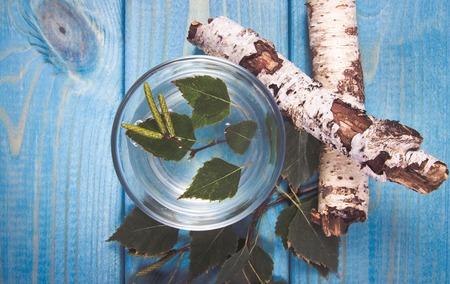 A glass of birch juice on blue wooden background. Close Up.の写真素材